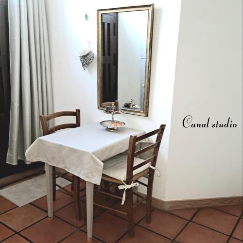 a table and chairs in a room with a mirror at La Maison du Canal - Canal Studio in Homps