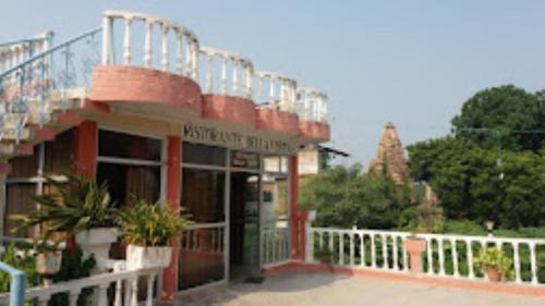 a building with a balcony with plants on it at Hotel Casa Di William Khajuraho in Khajurāho
