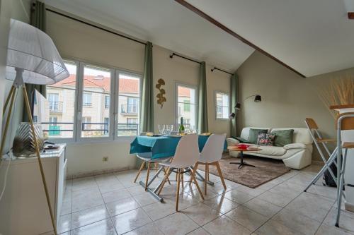 a living room with a blue table and chairs at Charmant Duplex 2 chambres pour 6 personnes - 10 min Disneyland - Free Parking in Bailly-Romainvilliers