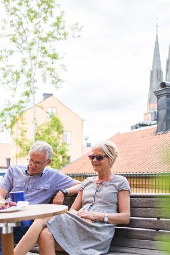 a man and a woman sitting on a bench at Akademihotellet in Uppsala