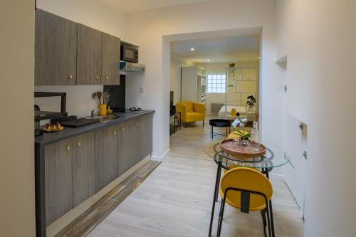 une cuisine et un salon avec une table et des chaises dans l'établissement Le Tournesol - Charmant Apt 4 personnes, à Saint-Quentin