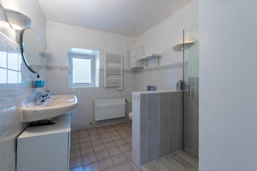 une salle de bain blanche avec un lavabo et une douche dans l'établissement Mas cévennol - Belle maison 3 chambres, à Saint-Florent-sur-Auzonnet