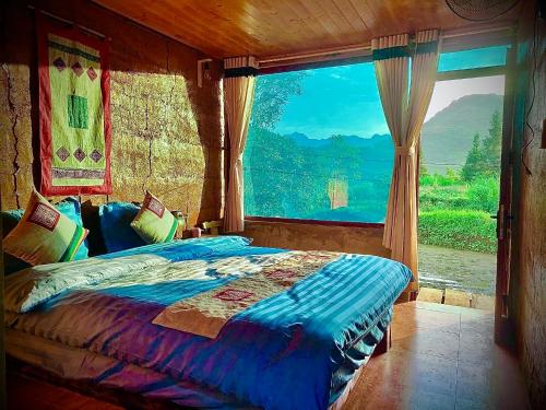 a bedroom with a bed with a large window at Mun Homestay in Ha Giang