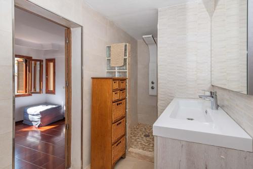 ein Badezimmer mit einem Waschbecken und einem Waschtisch mit einem Spiegel in der Unterkunft Villa Francesca in Port d'Alcúdia