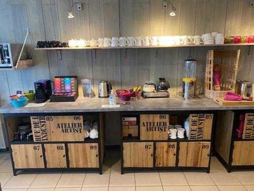 un bancone in una cucina con mobili in legno e un tavolo di Hotel du Porge a Le Porge