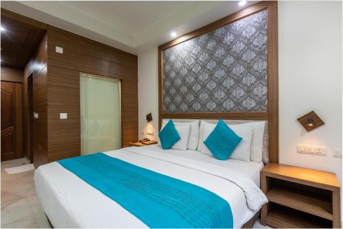 a bedroom with a large bed with blue pillows at Rock Castle By DLS Hotels in Shimla