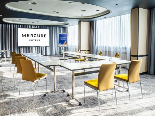 a conference room with white tables and yellow chairs at Mercure Dijon Centre Clemenceau in Dijon