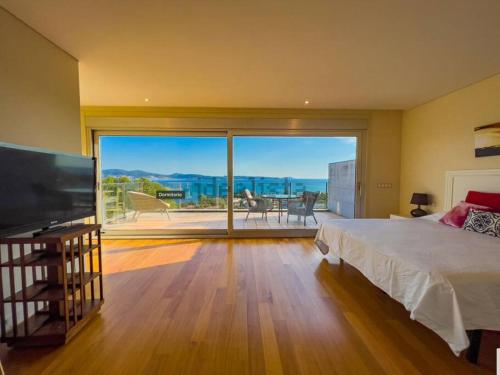 a bedroom with a bed and a large sliding glass door at Villa mirador de Sanxenxo in Sanxenxo