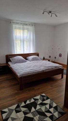 uma cama num quarto com uma janela e um tapete em Ferienwohnung Mostheuriger Leo-Hof Eva em Reichenau