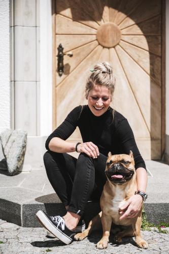 a woman sitting on steps with a small dog at Heimspitze - Alpenhotel & Wirtshaus in Gargellen