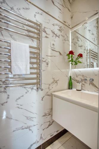 une salle de bain blanche avec un lavabo et un miroir dans l'établissement Luxueux 200m2 5CH Champs Elysées à 1min Perle Rare, à Paris