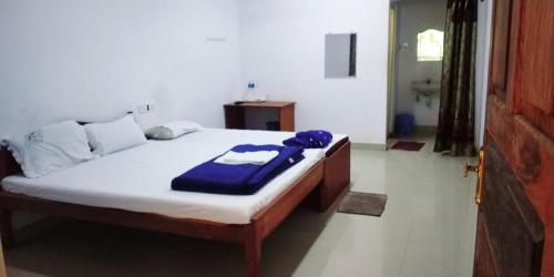 a bedroom with a bed with a blue blanket on it at port Blair in Port Blair
