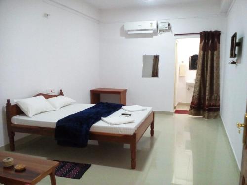 a bedroom with a bed and a table and a window at port Blair in Port Blair