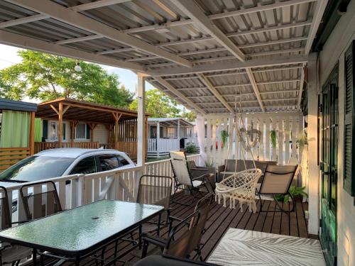 a patio with a table and chairs and a car at Privlaka Mobilhouses in Privlaka