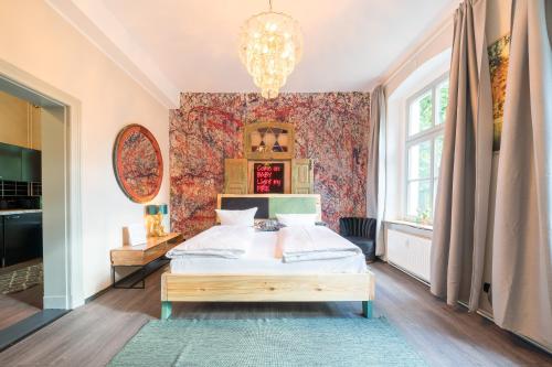 een slaapkamer met een bed en een kroonluchter bij Design Apartments - "Remise Blumberg" in Potsdam