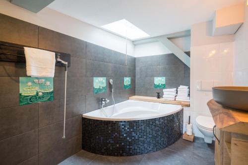 a bathroom with a tub and a toilet and a sink at Design Apartments - "Remise Blumberg" in Potsdam