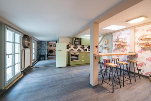 a kitchen with green appliances and a counter with stools at Design Apartments - "Remise Blumberg" in Potsdam