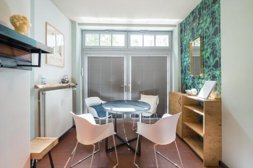 a dining room with a table and white chairs at Design Apartments - "Remise Blumberg" in Potsdam