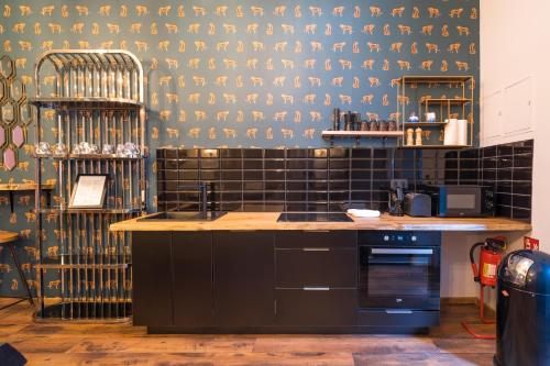 a kitchen with a counter and a black tiled wall at Design Apartments - "Remise Blumberg" in Potsdam
