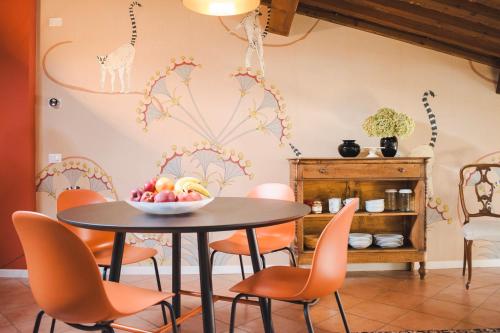 uma sala de jantar com uma mesa com uma taça de fruta em Vicolo Amanti Verona em Verona