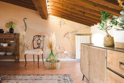 um quarto com uma cadeira e uma mesa com flores na parede em Vicolo Amanti Verona em Verona