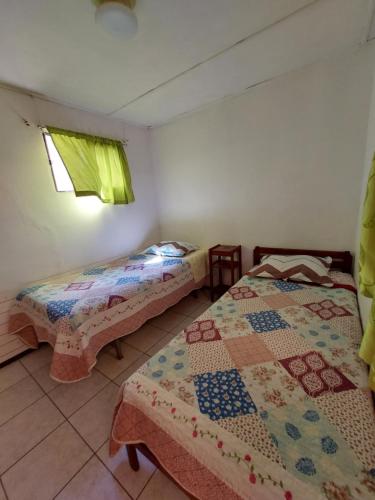 two beds in a room with a quilt on them at Hostal Venecia in Arica