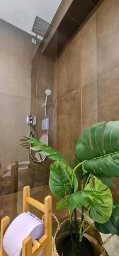 baño con ducha y planta verde en Cankar's Private Place, en Liubliana