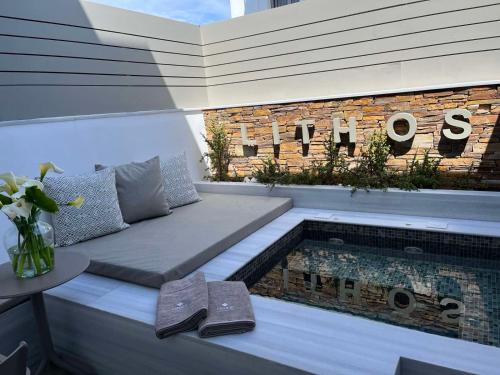 a patio with a bench next to a swimming pool at Lithos Luxury Suites in Tinos