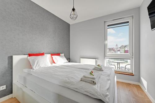sypialnia z dużym białym łóżkiem i oknem w obiekcie Apartamenty Apartinfo Centrum Władysławowo we Władysławowie