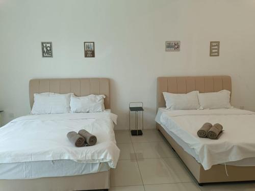 two beds with slippers on them in a bedroom at Cozy 4 bedrooms House by Mr Homestay, 3 mins to Kulim Landmark Centre in Kulim