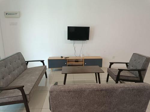 - un salon avec deux chaises et une télévision dans l'établissement Cozy 4 bedrooms House by Mr Homestay, 3 mins to Kulim Landmark Centre, à Kulim