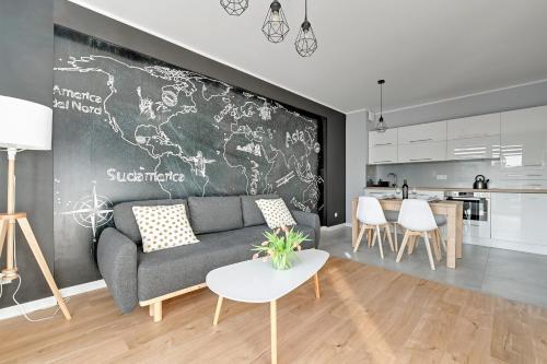 a living room with a couch and a chalkboard wall at Apartamenty Apartinfo Centrum Władysławowo in Władysławowo