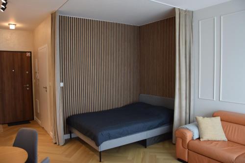 Habitación pequeña con cama y sofá en Warsaw City Break II, en Pruszków