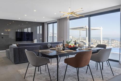 a dining room with a table and chairs and a couch at Villa Boa Nova Preta by LovelyStay in Funchal