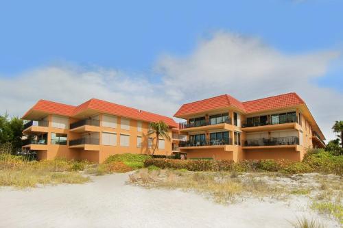 a building on the beach next to the sand at Playa Encantada 214 Home in Holmes Beach