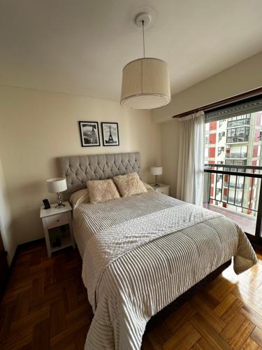 een slaapkamer met een bed en een groot raam bij Arena1 in Mar del Plata