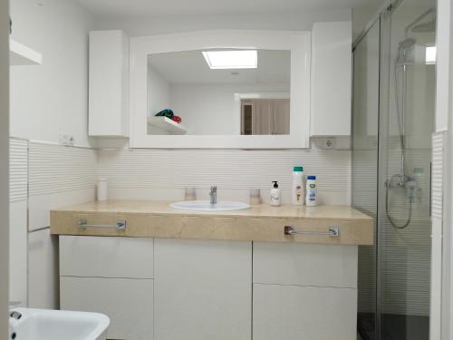 a bathroom with a sink and a mirror at Oasis Tamarindo 1 - Casa Rosa - Appartement 2 chambres climatisées in Corralejo