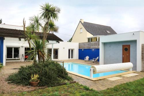 une maison avec une piscine devant une maison dans l'établissement La Villa du Pré Sec - Grande Plage à proximité, à Barneville-Carteret