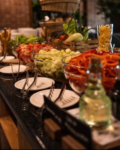 a buffet with plates and bowls of food on a table at Ведмежа гора Family Resort & Spa in Yaremche