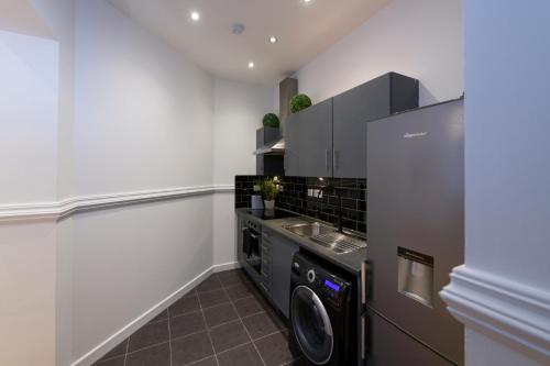 a kitchen with a washer and dryer in a room at Sidemersey Livings - Spacious Loft for bigger groups - Very Central and Cosy in Liverpool