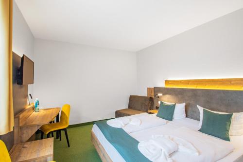 a bedroom with a bed and a desk and a table at Ferien Hotel Spreewald in Kolkwitz