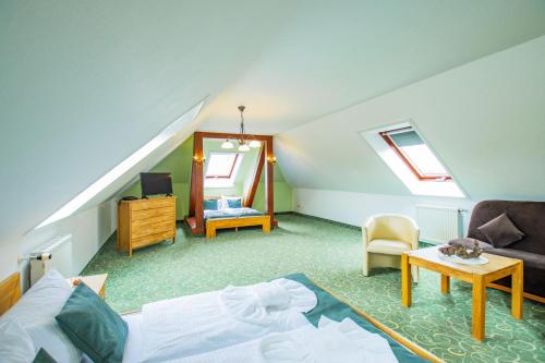 a attic room with a bed and a mirror at Ferien Hotel Spreewald in Kolkwitz