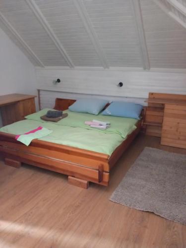 a bedroom with a bed with green sheets and blue pillows at APARTMAN ZELENA DOLINA in Čajetina