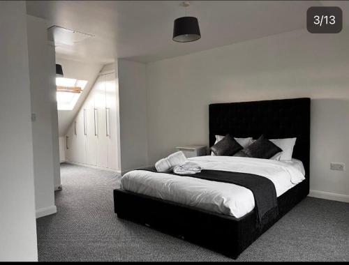 a bedroom with a large bed with a black headboard at Charming 3-Bed House in Gloucester in Gloucester