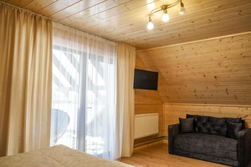 a living room with a couch and a window at Ankamy Sweet Home in Vorokhta