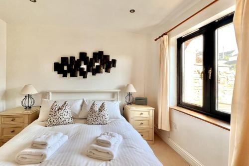 una camera da letto con un letto bianco e asciugamani di Central Spacious Ground Floor Flat with Courtyard a Kingsbridge