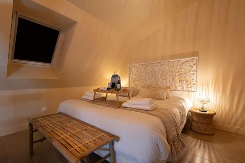 a bedroom with a large bed with a bench on it at Welcome to Coachella / Jacuzzi in Ivry-sur-Seine