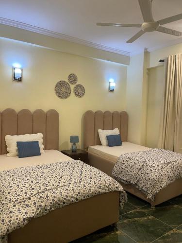 sypialnia z 2 łóżkami i wentylatorem sufitowym w obiekcie 2BR & 3BR Sea View Condos w mieście Dar es Salaam