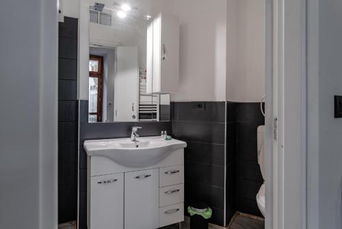 uma casa de banho com um lavatório branco e um espelho. em Ca' Sineo em Turim