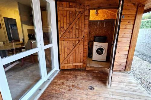 uma porta da frente de uma casa com uma máquina de lavar roupa em Le Chalet Du Redon em Margencel